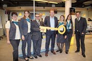 Tommy Baur, Mitglied der Konzernleitung (Mitte), übergibt Patrick Wiesli (Dritter von links) symbolisch den Schlüssel der Filiale. (Bild: Elena Fasoli)