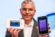 Patrick Weibel, Projektleiter 5G bei Swisscom, zeigt einen Hotspot (links) und einen Smartphone-Prototyp für 5G. (Bild: Alexandra Wey/Keystone (Luzern, 8. November 2018))