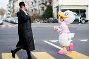 Kinder und Erwachsene feiern im Stadtviertel Wiedikon in Zürich das Purimfest. (Bild: Ennio Leanza/KEY)