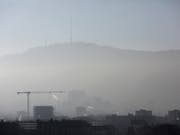 Feinstaub und Dunst über Zürich: Die Schweiz müsste beim C02-Abbau mehr leisten. (Bild: KEYSTONE/GAETAN BALLY)