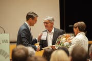 Zum Abschied gibt es für Urs Trümpler (Mitte) lobende Worte, Geschenke und Blumen. (Bild: PD)