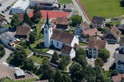Blick auf das Dorfzentrum Neuheim im Kanton Zug. Im Zentrum die Kirche Maria Geburt mit Friedhofkapelle rechts davon die Gemeindeverwaltung. (Bild: Stefan Kaiser (1. Juli 2015))