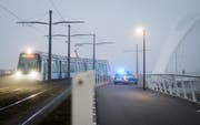 Die Strassenbahn fährt an der Deutsch-Französischen Grenze in Kehl über eine Brücke, während daneben Polizisten Fussgänger und Velofahrer kontrollieren. (Bild: Keystone)