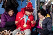 Bewundert: Olympiasieger Theo Gmür im Austausch mit Einheimischen. (Bild: Alexandra Wey/Keystone (Pyeongchang, 16. März 2018))