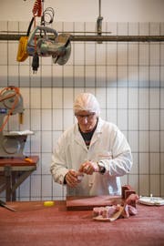 Metzger Alois Bucher füllt eine der Proben von einem Prüftier in den beschrifteten Behälter. Die Probe geht anschliessend direkt ins nebenan liegende Labor. (Bild: Dominik Wunderli, 19. Dezember 2018)