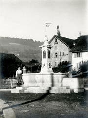 Der Krienser Dorfbrunnen auf dem Dorfplatz, kurz nach der Inbetriebnahme 1918. Hinten das Pfisterhaus, ehemals Bäckerei Fischer. Bild: Privatarchiv