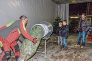 Da leuchten die Kinderaugen: Markus Koller verpackt einen Christbaum. (Bild: Christoph Heer)