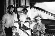 Ein deutscher Tourist fotografierte Anfang der 1960er-Jahre in der Bergstation die alte Sittlisalp-Bahn; in der Kabine seine Frau und rechts sein Sohn. Links im Bild sind Seilwart Brosi Arnold und Sohn Josef Arnold, heute freiwilliger Maschinist, zu sehen. Bild: PD
