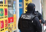 Vermummte Einsatzkräfte stehen vor einem Kiosk im Stadtteil Neukölln. Die Berliner Polizei ging im September gegen kriminelle arabische Grossfamilien vor. Bild: Paul Zinken/Keystone (Berlin, 5. September 2018)
