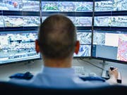 Ein Polizist sitzt im Polizeipräsidium an einem Arbeitsplatz der sogenannten intelligenten Videoüberwachung. Die Stadt Mannheim startet mit einer Videoüberwachung, die verdächtige Bewegungen auf öffentlichen Plätzen frühzeitig erkennen soll und den Sicherheitsbehörden meldet. (Bild: Keystone/DPA/UWE ANSPACH)