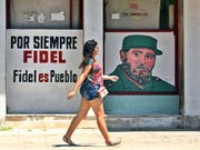 Für immer Fidel - Fidel ist das Volk. Die Kubanerin in Havanna scheint der Spruch an der Hauswand wenig zu beeindrucken. (Bild: KEYSTONE/EPA EFE/YANDER ZAMORA)