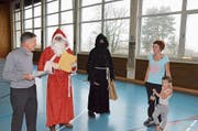 Stiftungspräsident Hanspeter Gantenbein überreicht mit Samichlaus und Schmutzli den Förderpreis an Barbara Hug. (Bild: Christoph Heer)