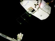 Beladen unter anderem mit Weihnachtsessen hat der private Raumfrachter «Dragon» an der Internationalen Raumstation ISS angedockt. Mit dem Roboterarm der Raumstation wurde die Kapsel eingefangen. (Bild: KEYSTONE/AP NASA TV)