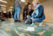 Janine Boog (links) und Isabelle Arnold begutachten die Luftaufnahmen im Ziegelei-Museum. (Bild: Stefan Kaiser (Hagendorn, 15. April 2017))