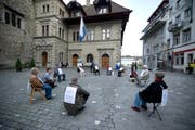 Die Organisation "Integrale Politik" inszeniert einen politischen Schweigekreis. dabei sitzen die Mitglieder schweigend auf dem Kornmarkt. (Bild: Dominik Wunderli / Neue LZ)