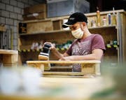 Flüchtling Mohammed Amo baut in der Schreinerei des Programms den Palettentisch «Tutto Paletti». (Bild: Stefan Kaiser (Zug, 20. Juni 2017))