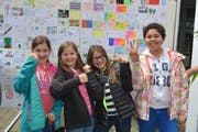 Schüler vor einer Wand voll Grusskarten, die der UNO in Genf überreicht werden sollen. (Bild: PD)