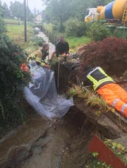 Die Einsatzkräfte bei der Sicherung der Bachmauer. (Bild: Feuerwehr Wiggertal)