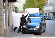 Zürich, 27. Mai: Hotelangestellte schirmen ab, wie ein ranghoher Fifa-Beamter von der Polizei abgeführt wird. (Bild: Pascal Mora/The New York Times)
