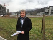 Der Krienser Gemeindepräsident Cyrill Wiget posiert beimAreal, wo die Pilatus-Arena mit ihrer Sporthalle für 4'000 Zuschauer entstehen soll. Rechts die Bahnstation Kriens-Mattenhof, im Hintergrund die Türme der Swisspor-Arena. (Bild: Marc Benedetti (Luzern, 19. Februar 2018))
