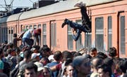 Flüchtlinge klettern bei Gevgelija in Mazedonien in einen Zug nach Serbien, wo sie anschliessend in EU-Länder gelangen wollen. In Brüssel streitet man sich derweil über einen Verteilschlüssel für die Asylsuchenden. (Bild: EPA/Georgi Licovski)