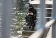 Eine verhüllte Touristin sitzt am Ufer der Reuss in Luzern. (Bild: Boris Bürgisser (Luzern, 31. August 2016))