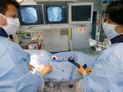Behandlung einer Herzinfarkt-Patientin - mit den Daten aus dem Herzinfarktregister sollen Patienten besser behandelt werden können. (Symbolbild, gestellte Aufnahme) (Bild: KEYSTONE/YOSHIKO KUSANO)