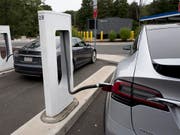 Ein Tesla-Auto wird an einem Supercharger aufgeladen. Bislang war das gratis. Für Neukunden wird künftig eine "kleine Gebühr" fällig. (Bild: KEYSTONE/AP/MARK LENNIHAN)