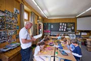 Der Lehrplan 21 strebt einen Paradigmenwechsel an: weg von Inhalten, hin zu Kompetenzen. Im Bild: Primarschüler und ihr Lehrer im Unterricht. (Bild: Keystone)