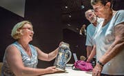 Archäologin Eva Roth (links) begutachtet den Bierkrug des Ehepaars Külling aus Unterägeri. (Bild: Patrick Hürlimann (Burg Zug, 24. Juni 2017))