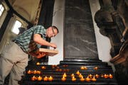 Sakristan Kurt Rohrer legt neue Kerzen parat. Deren Russ verteilt sich in der gesamten Kirche. (Bild: Corinne Glanzmann/Neue OZ)