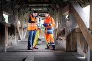 Ivo Burkhalter und Matthias Flühler von der Trigonet AG beim Vermessen der Spreuerbrücke mit Lasertechnologie. (Bild Pius Amrein/Neue LZ)