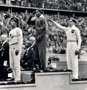 Siegerehrung im Weitsprung: Jesse Owens (Mitte) salutiert, Luz Long (rechts) zeigt den Hitlergruss. (Bild: Keystone)