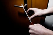 Ein Einbrecher beim Versuch, eine Türe Türe gewaltsam zu öffnen (gestellte Szene). (Bild: Archiv Neue LZ)