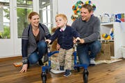 Timo (mit seinen Eltern Petra und Björn Portmann) hat in den letzten Monaten viel erreicht. Das Gehen am Minirollator ist eine seiner neuen Fähigkeiten. (Bild: Eveline Beerkircher/LZ)