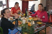 Erst die Arbeit, dann der Genuss: Michelle Gisin (links), Physiotherapeutin Miryam Leyrer (Mitte) und Wendy Holdener beim Mittagessen, das sie selbst gekocht haben. (Bild: Stefan Klinger)