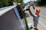 Ein Plakatkleber der Werbefirma APG|SGA befestigt ein Plakat (Symbolbild). (Bild: Keystone / Laurent Gilliéron)