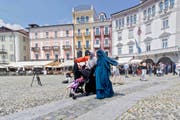Nora Illi (im grünen Niqab), Frauenbeauftragte des Islamischen Zentralrats der Schweiz, am 1. Juli 2016 auf der Piazza Grande in Locarno. Mit diesem Auftritt provozierte sie die erste Busse aufgrund des Burka-Verbots. (Bild: Keystone/Paplo Gianinazzi)