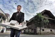 Gemeindeammann Pius Kaufmann Mitte Mai mit dem Modell, wie die Kreuzscheune (im Hintergrund) umgebaut werden soll. (Bild: NadiaSchärli / Neue LZ)