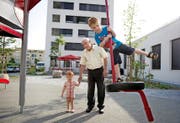 Jost Schumacher mit Lukas (4), der sich auf den Kindergarten freut, und dessen Bruder Dominik (1) vor dem Kindergarten Tribschenstadt 2 (Erdgeschoss, weisses Gebäude hinten). (Bild Corinne Glanzmann)