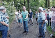 Thomas Neurauter, Vorstandsmitglied von Pro Natura Zug, führt eine Gruppe durch den Wald. (Bild: Werner Schelbert (Hagendorn, 22. Juli 2017))