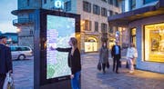 Eine Frau bedient die digitale Stadtkarte am Schwanenplatz. (Bild: Clear Channel / Kilian J. Kessler)