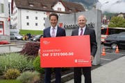 Bankpräsident Kuno Kennel(links) und Peter Hilfiker, Vorsitzender der Geschäftsleitung der Schwyzer Kantonalbank, mit dem symbolischen Jubiläums-Check. (Bild: PD)