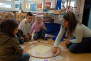 Eine Kindergärtnerin bringt ihrer Gruppe bei, was der Unterschied zwischen einem Schloss und einem Haus ist. (Bild Urs Rüttimann/Neue NZ)