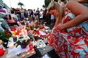 Personen legen in Nizza Blumen nieder. (Bild: AP / François Mori)