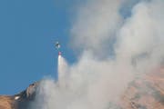 Der Helikopter wirft Wasser ab, um den Waldbrand am Bristenstock zu löschen. (Bild: Leserbild Irene Baumeler - Villiger)