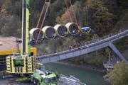 Der Kran hievt den ersten Wagen aufs Trassee. (Bild: Urs Flüeler / Keystone (Schwyz, 12. Oktober 2017))