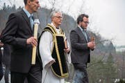 Oben: Diakon Burghard Förster (Mitte) führt die Prozession zum Grab im Friedhof Friedental an. Unten: Blick in das Grab mit Knochen von ungefähr 300 Menschen. (Bilder: Dominik Wunderli (Luzern, 11. Dezember 2017))