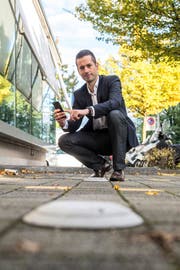 Oliver Stahel auf einem Parkplatz mit Sensor. Dieser meldet ans Smartphone, wenn der Platz frei ist.