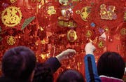 In Peking gibt es bereits zahlreiche Dekorationen zur Feier des Hundejahres zu sehen. (Bild: Mark Schiefelbein/AP (13. Februar 2018))